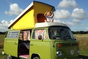 A child with their thumbs up in the camper van