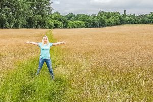 Woman posing with hands out in field