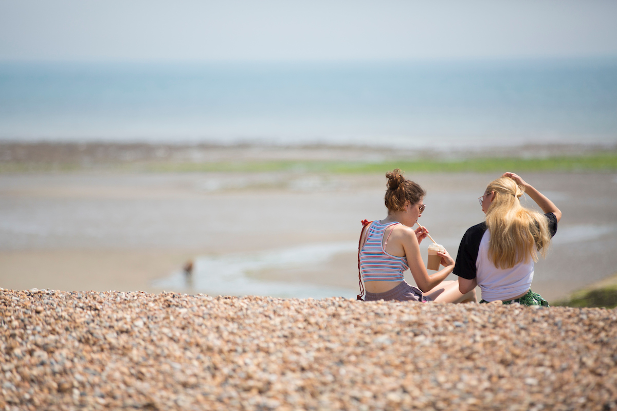 Two girls sitting on Climping Beach