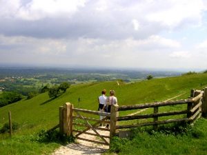 Two people enjoying a walk in the green countryside in Sussex