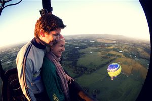 A couple in a hot air balloon looking down at the countryside in Susex