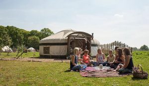 A group of ladies having a picnic outside a yurt