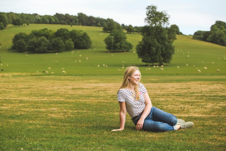 Woman sitting on grass in the West Sussex countryside