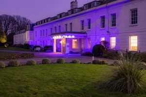 Exterior shot of Avisford Park Hotel with purple light