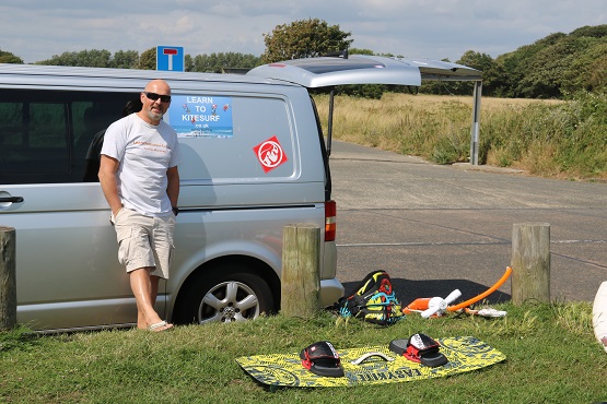 Owner of Learn to kitesurf next to his van waiting for a lesson in Sussex