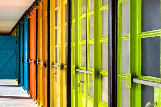 Brightly coloured beach hut doors of The East Beach Studios in Worthing