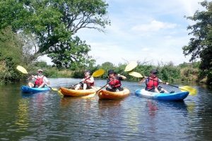 Group kayaking on a river with Hatt Adventures