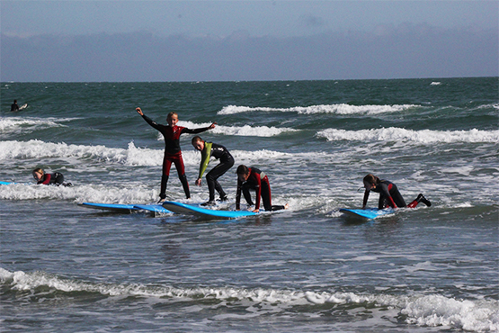 Young children learning to surf in the sea