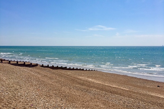 Goring Gap Beach with pebbles, groynes and the blue sea