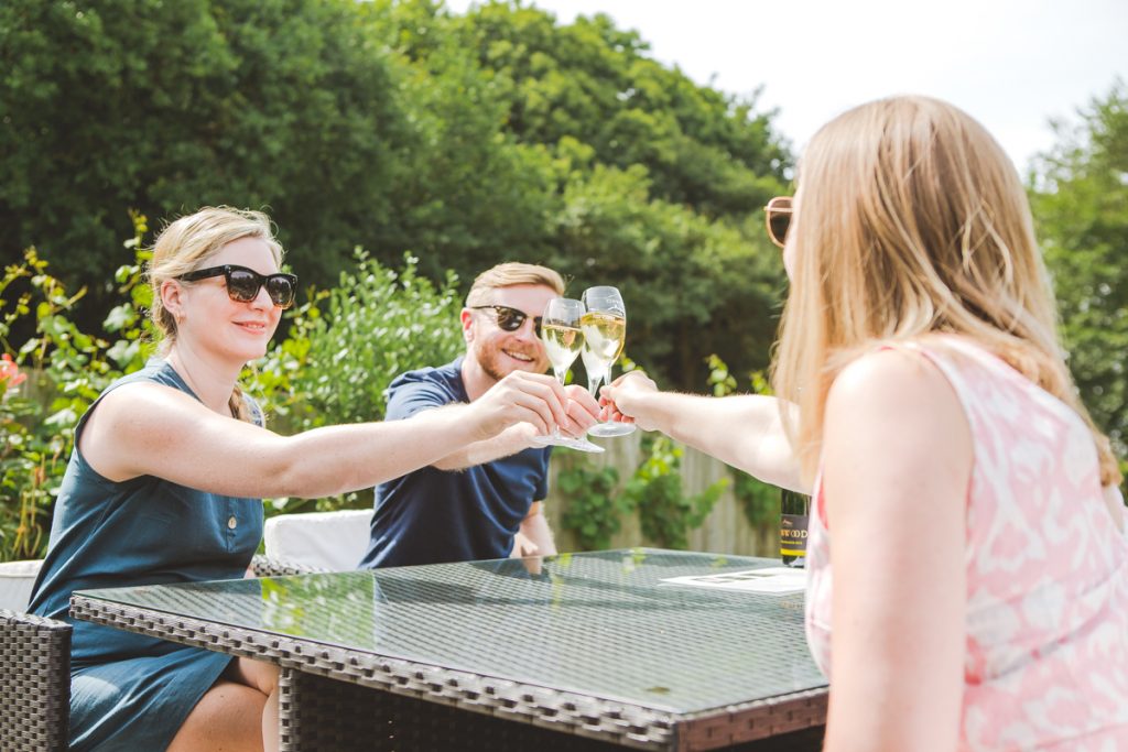 Friends toasting at a wine tasting afternoon at a vineyard in sussex in the sun
