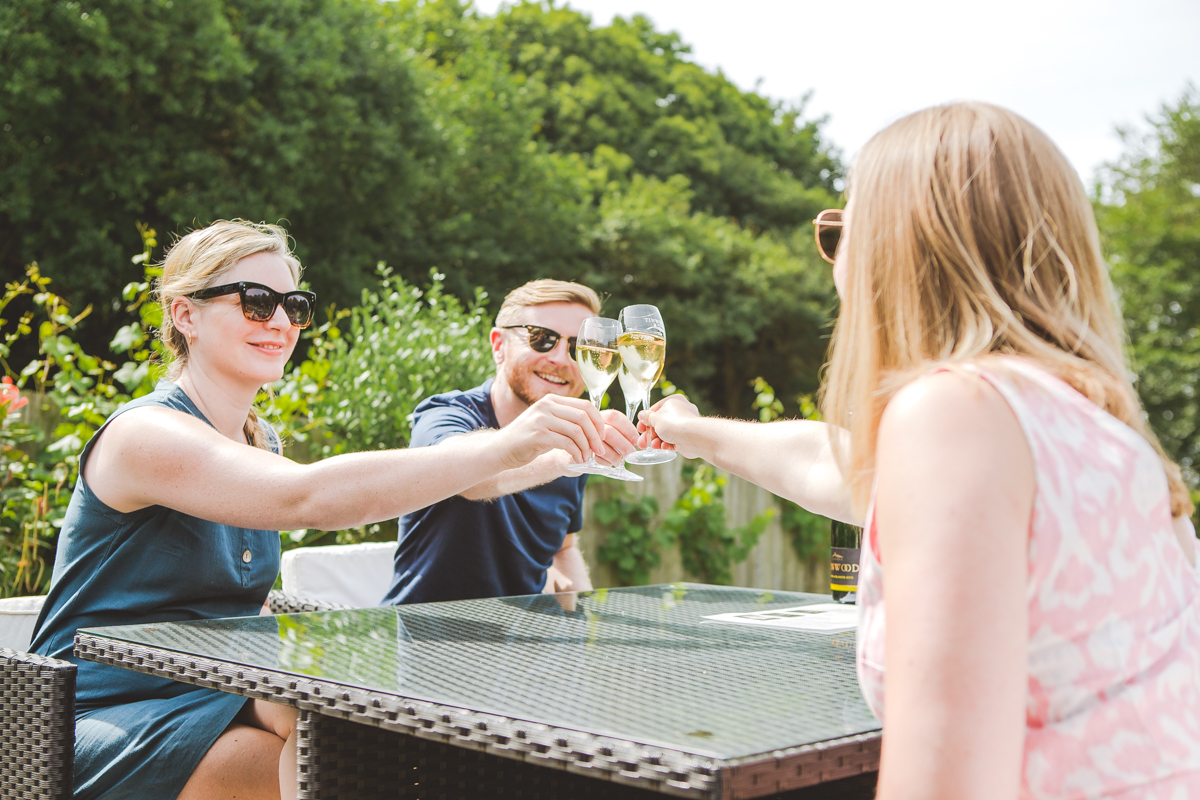Friends toasting at a wine tasting afternoon at a vineyard in sussex in the sun