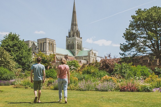 A couple walking in the gardens of Chichester Cathedral