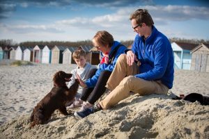 A family and dog on the sandy beach in West Sussex
