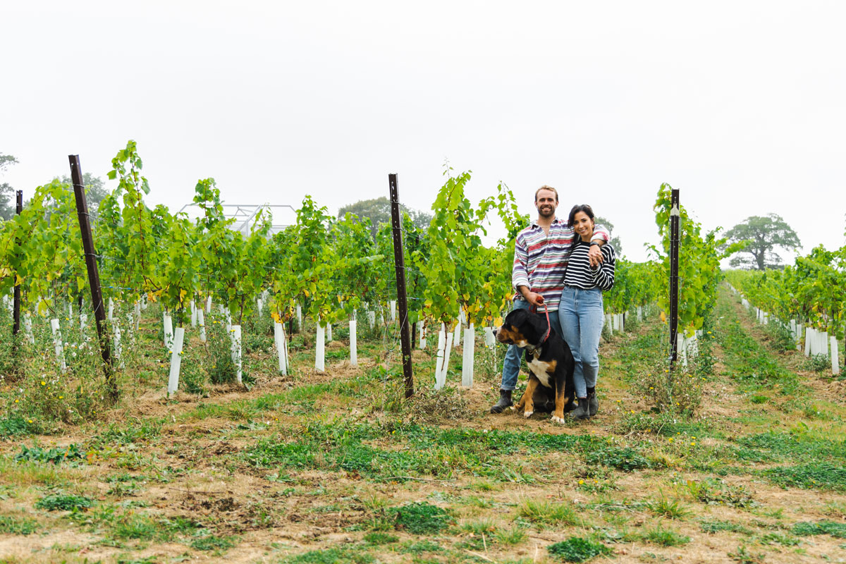 A couple standing in front of the vines atKinsbrook Vineyard