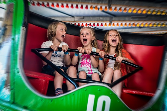 Three young children on the waltzer at Harbour Park