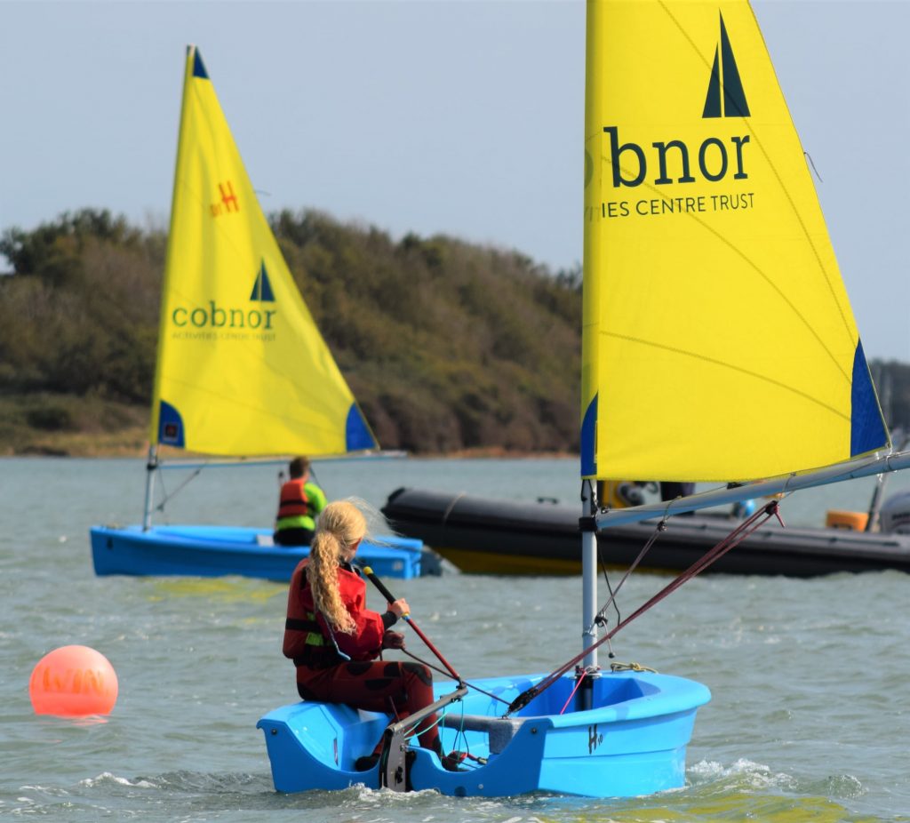 Children learning to sail in the water with Cobnor Activities