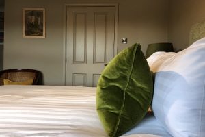 Green pillow on double bed at the East Beach Guest House in Littlehampton