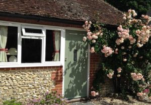 A small farmhouse with roses around the door