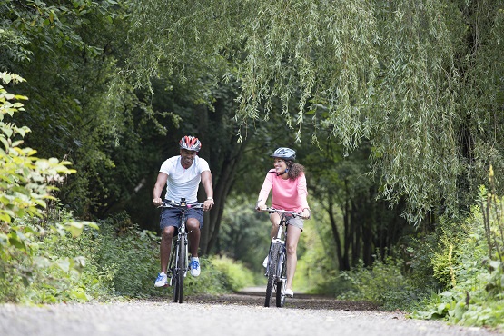 Two cyclists riding through West Sussex countryside
