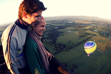 A couple enjoying a hot air balloon ride overlooking the West Sussex countryside