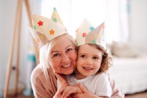 An older lady and a child hugging in crowns