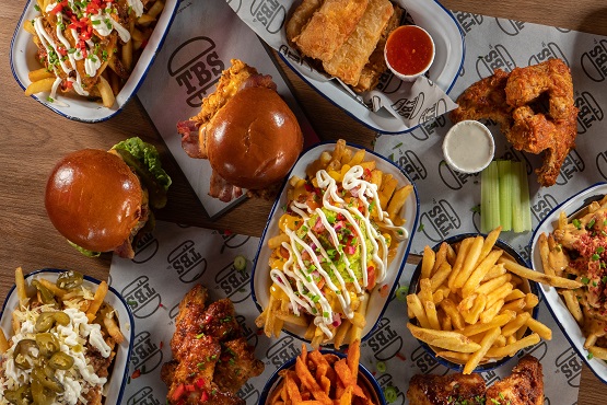 Burgers, loaded fries and chicken wings on a table