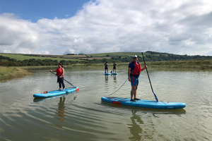 Clare Osbourne teaching paddleboarding in West Sussex river